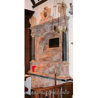 St Michael, Theydon Mount Church – Monument 3: This standing wall-monument depicts Sir William Smith d.1626 (builder of the church) and his wife, Bridget. Sir William is slightly higher than, and behind, his wife. To the pious memorie of her loved and loving husband Sr William Smyth of Hill Hall in the County of Essex knight who till he was xxx yeares old followeed the warres in Ireland with such aprobation that he was chosen one of the Colonels of the Army. But his uncle Sr Thom. Smyth Chancellor of the Garter & Principall Secretary of State to two princes King Edward the sixt & the late Queene Elizabeth of famous memorie dying he returned to a faire & full inhaeritance, and so bent himselfe to the afaires of the countret that he grewe alike famous in the artes of peace as warre. All offices that sorted with a man of his quality ge right worshipfully performed and dyed one of the Deputy Lieutenants of the Shire. A place of no smalle trust and credit. Bridget (his unfortunate widow who during the space of XXXVII yeares bare him III sonnes and IIII daughters) daughter of Thomas Fleetwood of the Vache in the County of Buckingham Esq and sometimes Mr of the Mint to allay her languor and longing after so deare a companion of her life rather to expresse her affection than his merit this monument erected destinating the same to herself theire children and posteritie he lived years LXXVI dyed the XII day of December 1626. The arched recess and background are very similar to the monument to his father ...