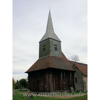 St Margaret of Antioch, Margaretting Church – Exterior 2: My visit was on rather a gloomy looking day, but, despite the darkness, the sheer size of the tower is easily discerned. Like nearby Blackmore, the tower sits on ten posts. Three pairs of arched braces connect free standing posts in the N-S direction, whilst from E-W, the posts are spanned by lower and smaller arched braces.