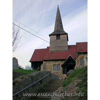 St Nicholas, Laindon Church – Exterior 5: This view up to the church shows the timber belfry, with its dark weather-boarding, and its broach spire.