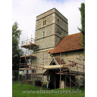 St Mary the Virgin, Strethall Church – Exterior 1: Strethall church is one of those churches which you arrive at, and instantly feel as though you are intruding on a farmer's property. You park near some barns, and walk alongside a few tractors and the like, glimpsing the church through the trees. It is not obvious, from the North, quite how one enters the churchyard. The lowest stage of this tower is Norman, whilst the upper is C14.