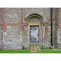 St Michael & All Angels, Copford Church – Exterior 4: The N doorway into the nave is Norman. It has two orders of columns with primitive capitals, and two roll mouldings in the arch.
