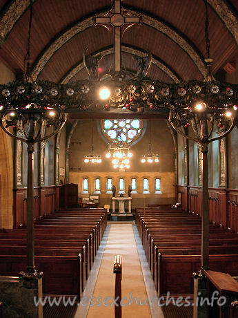 St Mary the Less, Great Warley Church - The view west gives us our first proper glimpse of the 
magnificent W rose window, by Heywood Sumner.
The
church's website 
gives some more information on this artist.
Also present, but rather shaded in this view, is the 
magnificent chancel screen, shown more clearly (though not fully) in the 
Miscellaneous area.

