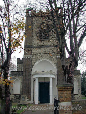 St Peter & St Paul, Dagenham Church - Curly battlements top a West tower with semicircular W porch with Gothick quatrefoils with shaft rings.
