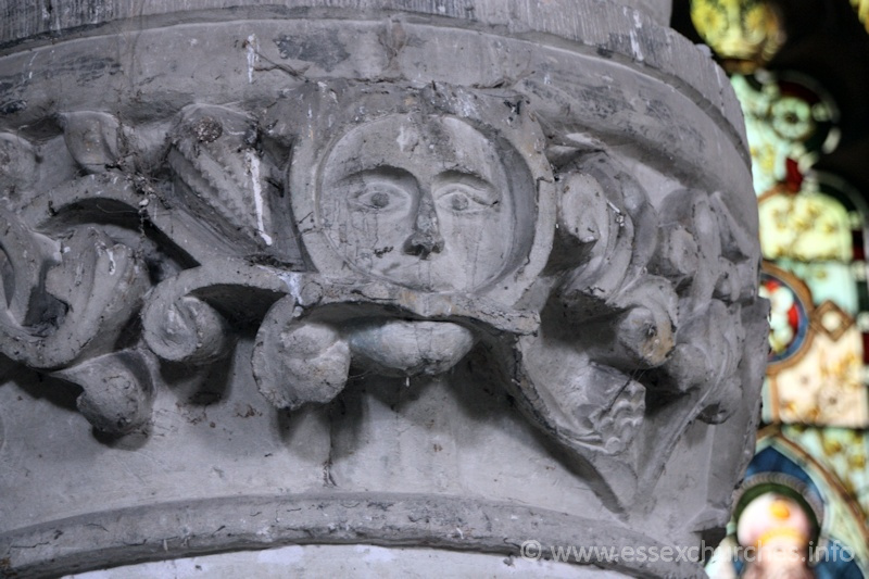 St John the Baptist, Mucking Church - Circular pier in the S aisle arcade, with stiff-leaf capital. Two faces appear - one facing north, the other south-west. This one - north facing, is a green man.