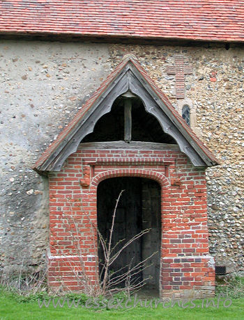 Dedication Unknown, Mashbury Church - This tudor brick porch was built approx 1500. The roof of both 
this porch, and the nave are C15.
Note the obsured Norman window, and the cross shape, formed 
from tiles.
