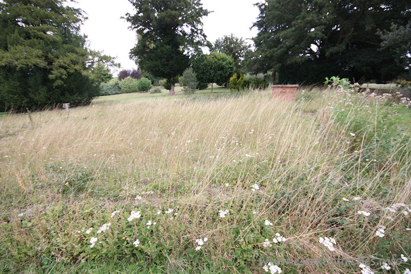 St Margaret, Markshall Church - View from just to the left of southernmost part of hexagonal church structure. See stonework in grass, along with Google mapping satellite view in map below.